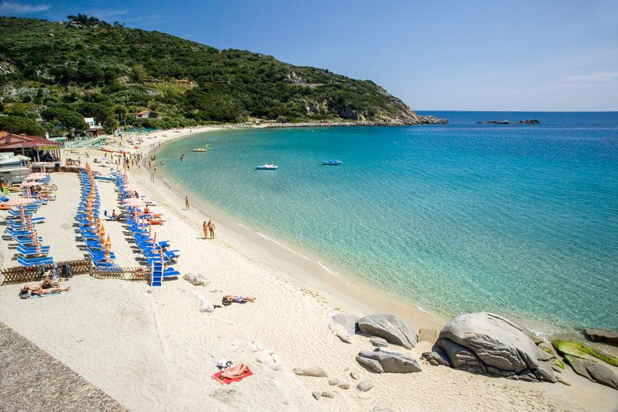La spiaggia di Cavoli, con la baia turchese e gli ombrelloni